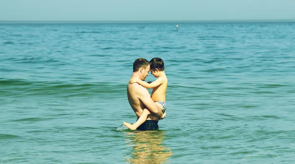 Far och son dopp i havet. Svartvitt foto. — Stockfoto