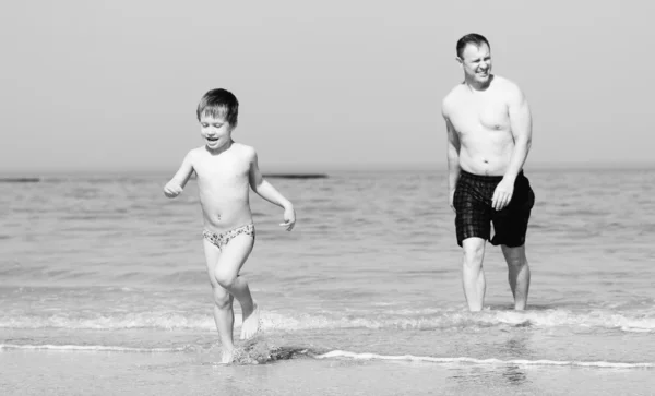 Pai e filho vão nadar no mar. Foto em styl de imagem antiga — Fotografia de Stock