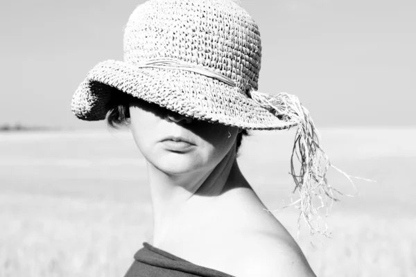 Jolie femme dans le chapeau sur le terrain. Photo noir et blanc . — Photo