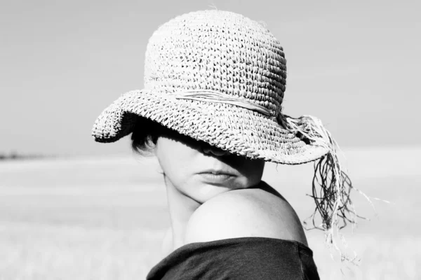 Hübsche Frau mit Hut auf dem Feld. Schwarz-Weiß-Foto. — Stockfoto