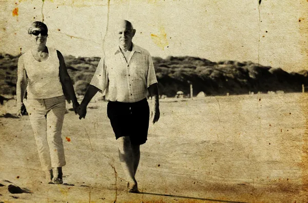 Felice coppia anziana che cammina insieme su una spiaggia. Foto nella vecchia im — Foto Stock