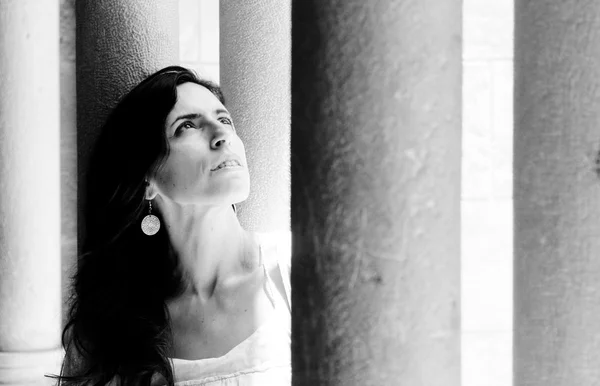 Hermosa mujer en vestido en el fondo de las columnas —  Fotos de Stock