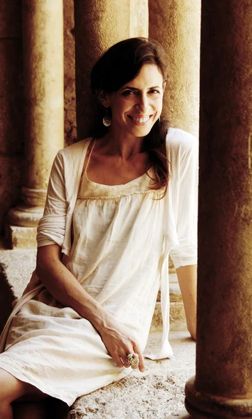 Mooie vrouw in jurk op de achtergrond van kolommen — Stockfoto