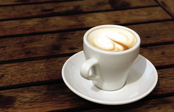 Kopp kaffe på trä bakgrund — Stockfoto