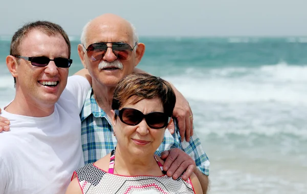 Adult son with his parents walking on the beach — Stock Photo, Image