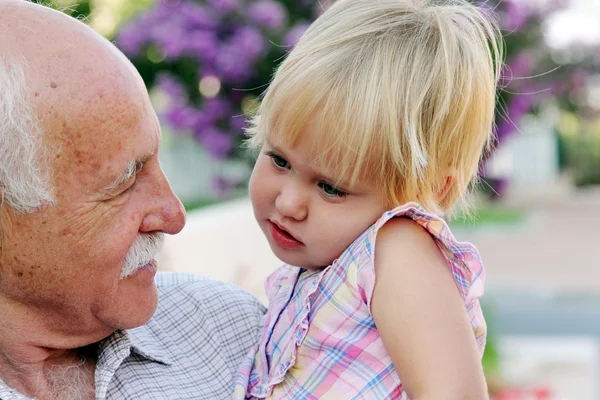 Grandfather holding his 2 year old granddaughter — Stock Photo, Image
