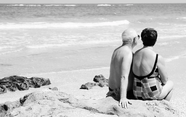 Retrato de casal de idosos felizes sentados juntos em uma praia — Fotografia de Stock