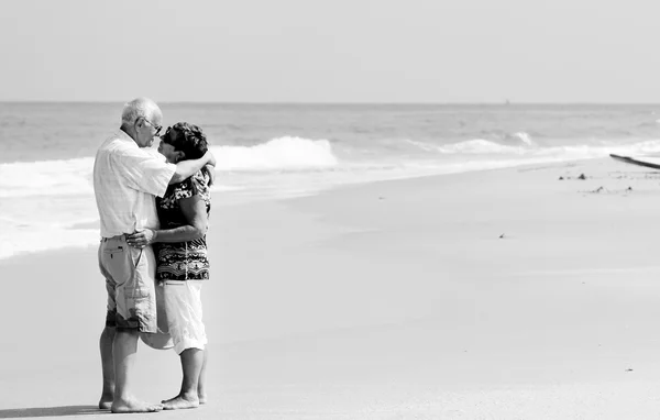 Gelukkige senior paar lopen samen op een strand — Stockfoto