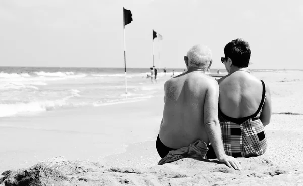 Retrato de casal de idosos felizes sentados juntos em uma praia — Fotografia de Stock