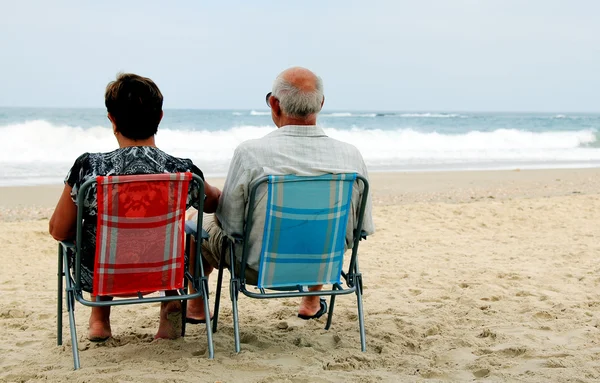 История пожилой пары на песчаном пляже — стоковое фото