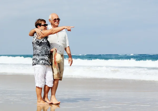 Счастливая старшая пара, гуляющая вместе по пляжу — стоковое фото