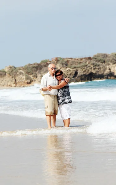 Heureux couple de personnes âgées marchant ensemble sur une plage — Photo