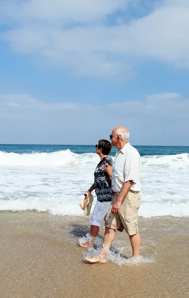 Счастливая старшая пара, гуляющая вместе по пляжу — стоковое фото