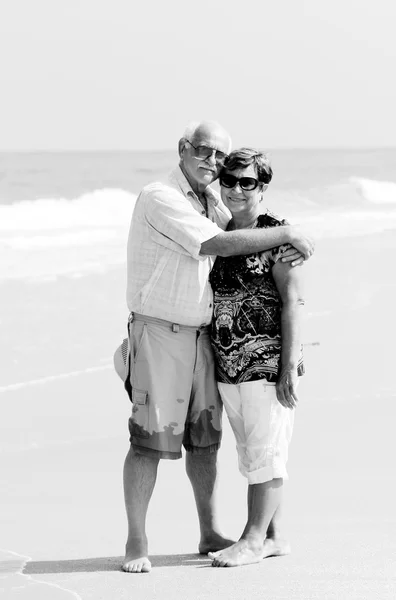 Happy senior couple walking together on a beach — Stock Photo, Image