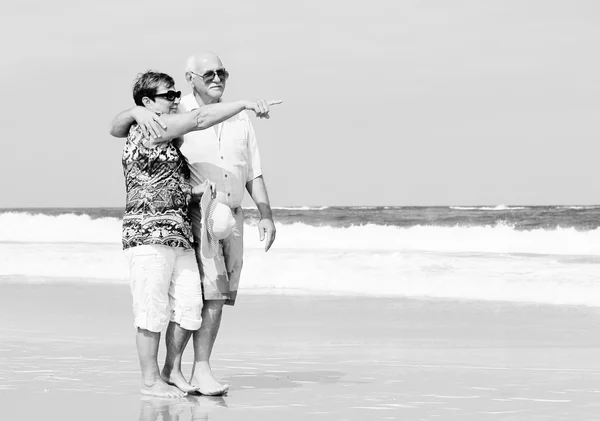 Casal sênior feliz andando juntos em uma praia — Fotografia de Stock