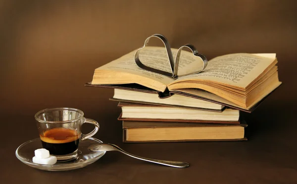 Cup of coffee next to vintage books — Stock Photo, Image