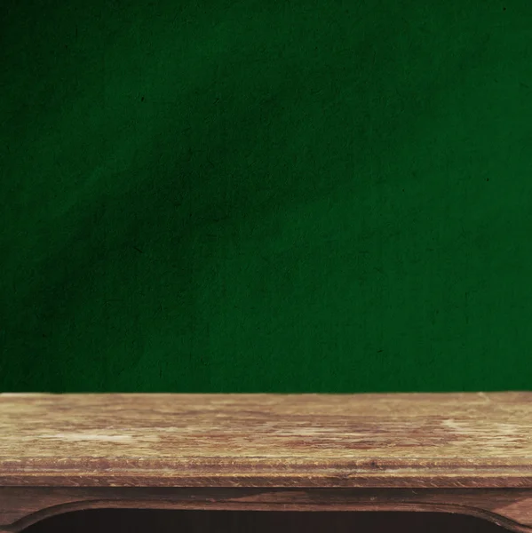 Винтажный фон с деревянным столом и тертой зеленой стеной — стоковое фото