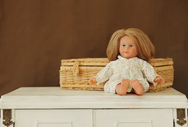 Babypuppe sitzt auf Vintage-Tisch — Stockfoto