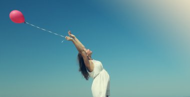 jonge zwangere vrouw met rode ballon