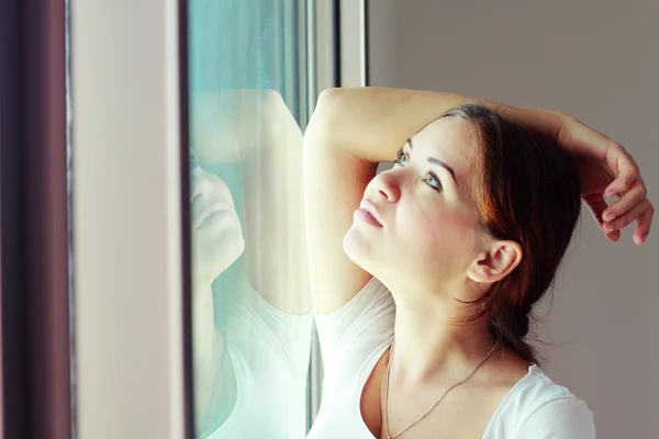 Schöne traurige Frau steht vor dem Fenster — Stockfoto