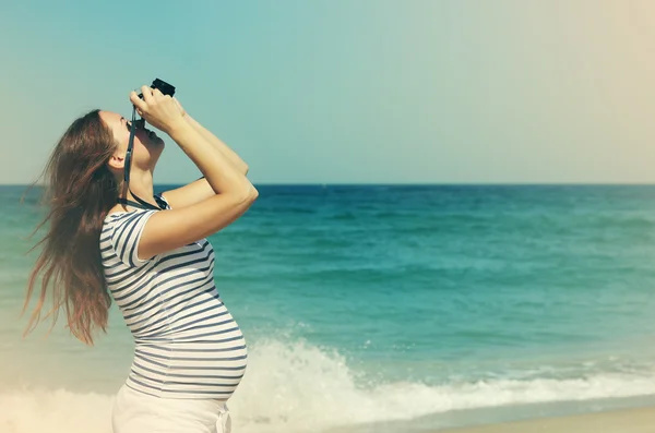 Young pregnant woman holding vintage camera — Stock Photo, Image