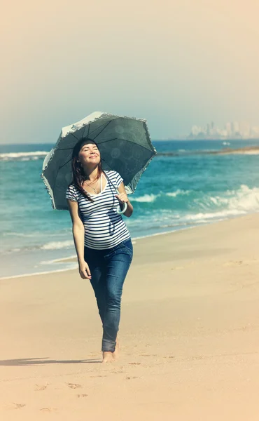 Junge schwangere Frau zu Fuß am Strand — Stockfoto