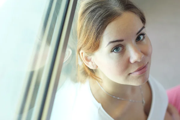 Wanita cantik yang duduk di depan jendela — Stok Foto