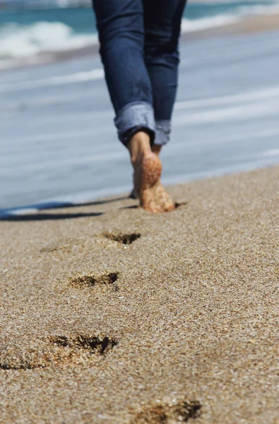 Jonge vrouw wandelen op het strand. focus op het zand. — Stockfoto