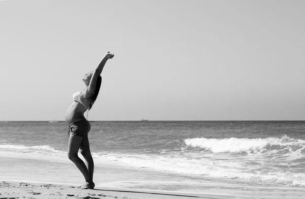 浜で歩いて若い妊娠中の女性 — ストック写真