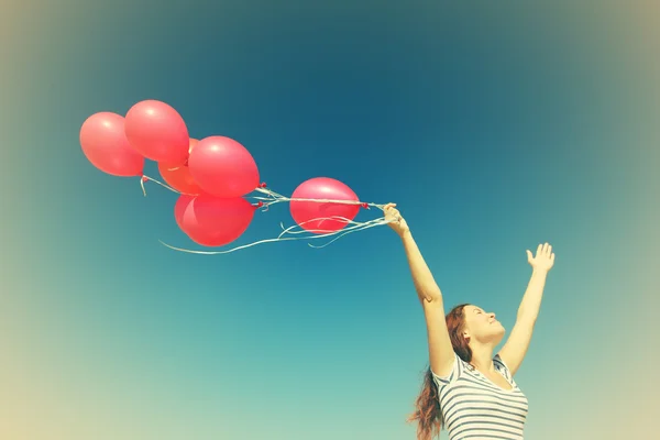 Junge schwangere Frau mit roten Luftballons — Stockfoto