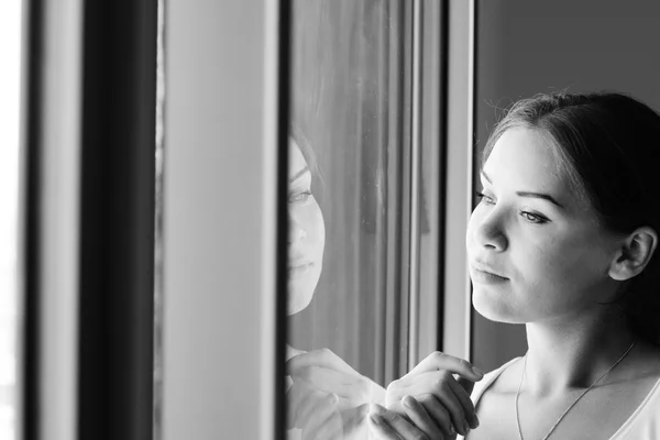 Beautiful woman stands in front of the window — Stock Photo, Image