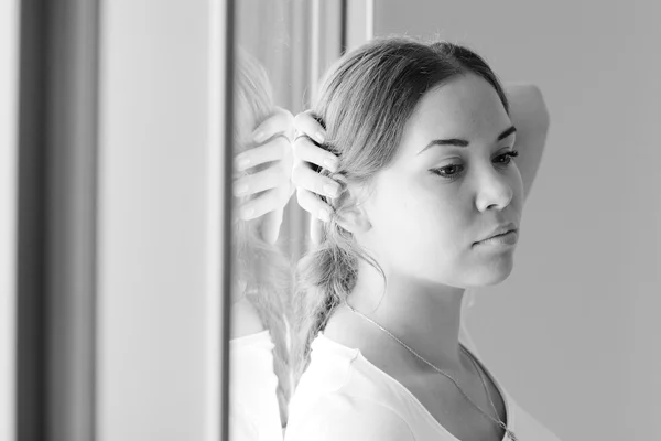 Beautiful woman stands in front of the window — Stock Photo, Image