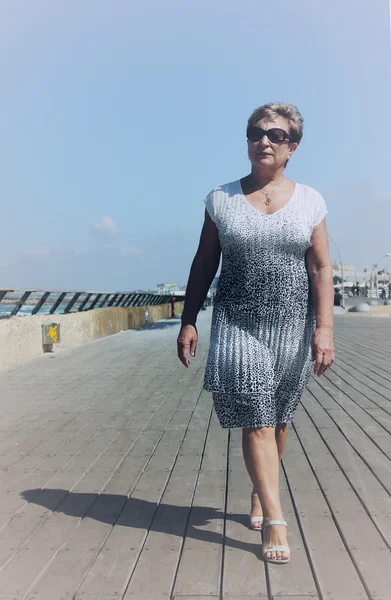 Felice donna matura a piedi vicino al mare — Foto Stock