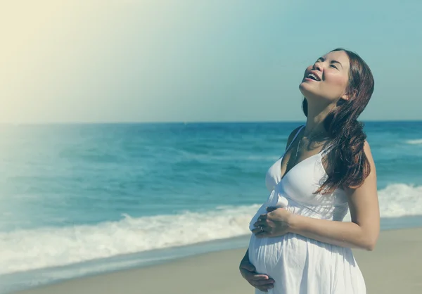 Mujer embarazada joven caminando en la playa — Foto de Stock