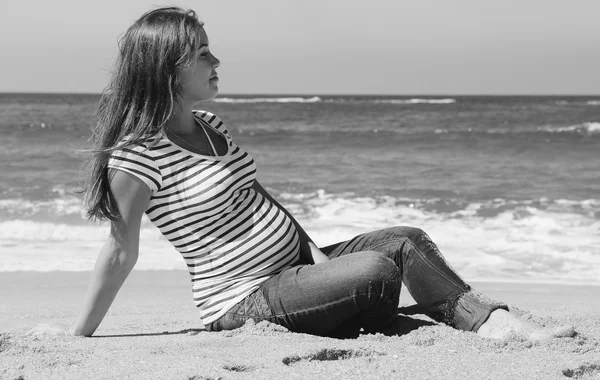 ビーチの上に座って美しい妊娠中の女性 — ストック写真