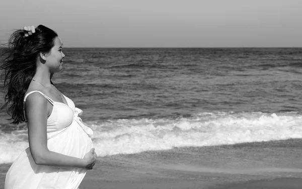 Piękna ciężarna kobieta stojąca na plaży — Zdjęcie stockowe