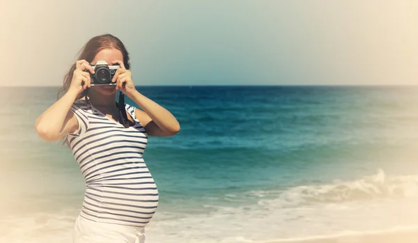 Young pregnant woman holding vintage camera — Stock Photo, Image