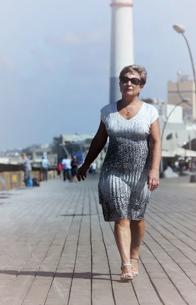 Felice donna matura a piedi vicino al mare — Foto Stock