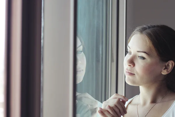 Vacker kvinna står framför fönstret — Stockfoto