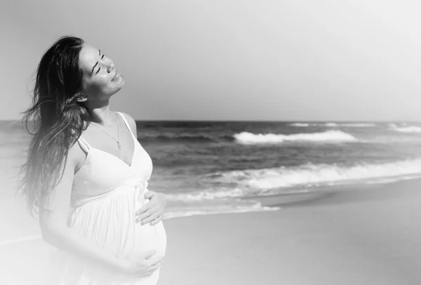 Belle femme enceinte debout sur la plage — Photo