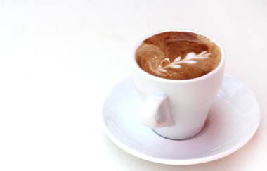 Beyaz masada bir fincan kahve.