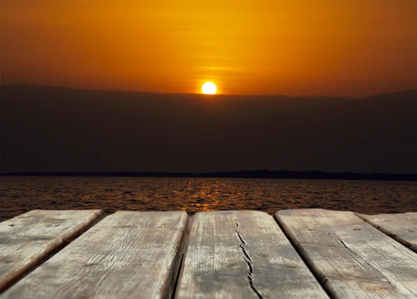 Nascer do sol no mar com fundo de mesa de madeira — Fotografia de Stock