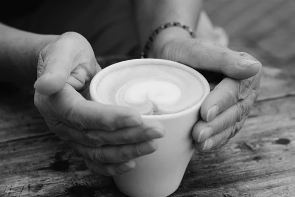 Mayores manos de mujer sosteniendo taza de café caliente —  Fotos de Stock