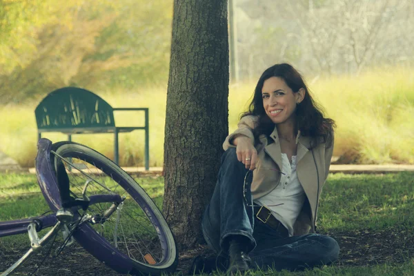 Mulher com bicicleta retro em um parque — Fotografia de Stock