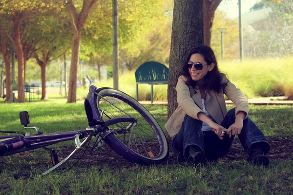 Kvinna med retro cykel i en park — Stockfoto