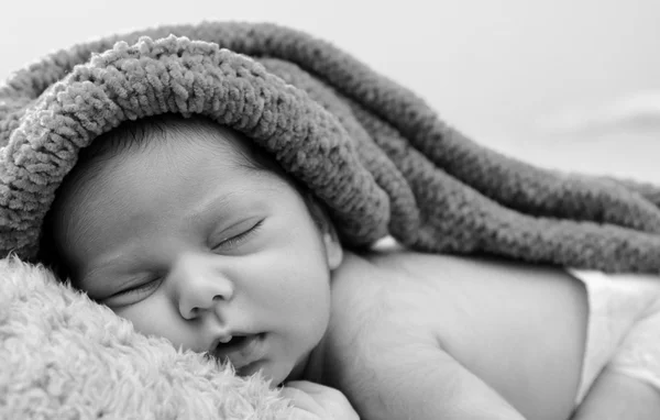 Bebê recém-nascido está usando um chapéu azul e deitar-se dormindo — Fotografia de Stock