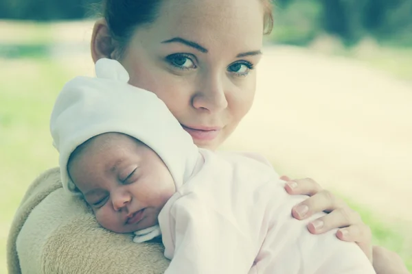 Joven madre con su bebé recién nacido al aire libre — Foto de Stock