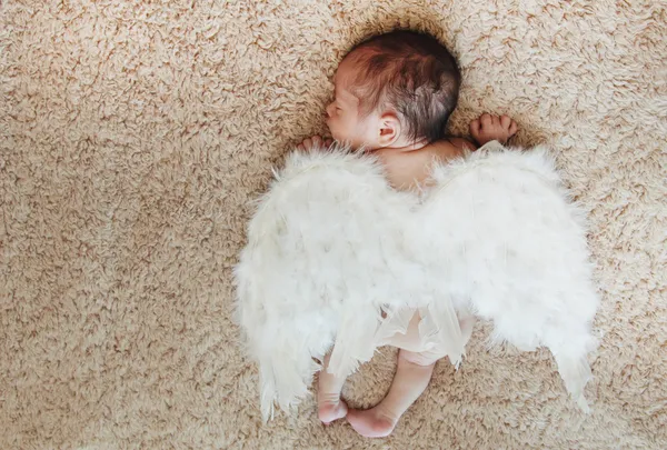 Pequeno bebê recém-nascido nu dormindo com asas de anjo — Fotografia de Stock