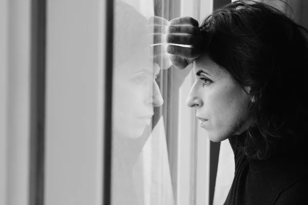 Schöne 35-jährige Frau steht vor dem Fenster — Stockfoto