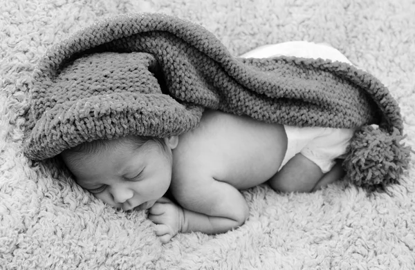 Newborn baby is wearing a blue hat and laying down sleeping — Stock Photo, Image